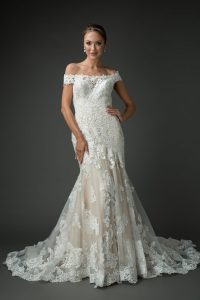 Off-the-shoulder lace wedding dress with intricate floral lace detailing and a fitted bodice that flows into a flared skirt with a soft train, creating a timeless and elegant bridal silhouette.