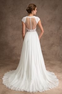 Back of bride wearing ivory silk skirt and lace top wedding dress with cap sleeves and buttons down illusion back