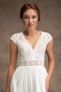 Bride wearing ivory silk skirt and lace top wedding dress with cap sleeves