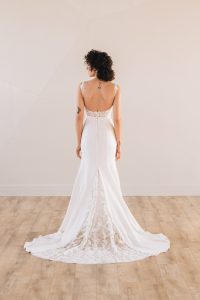 Back of bride wearing a square neck trumpet wedding dress with a lace train