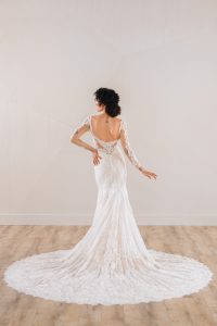 Stunning long sleeve lace wedding dress featuring an open back, delicate floral lace, and a dramatic train for a timeless and elegant style.