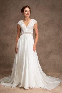 Bride wearing ivory silk skirt and lace top wedding dress with cap sleeves