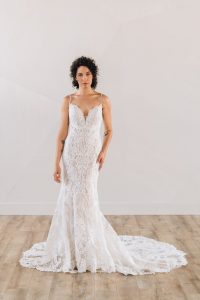 Bride wearing beaded art deco wedding dress with thin straps and deep v neckline