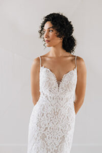 Bride wearing beaded art deco wedding dress with thin straps and deep v neckline