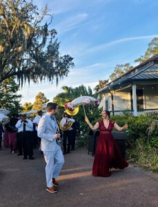 bride in new orleans wearing red wedding dress marching through street