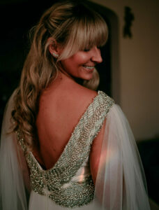 Grace + Ivory bride wearing wedding dress with green beading and tulle wings