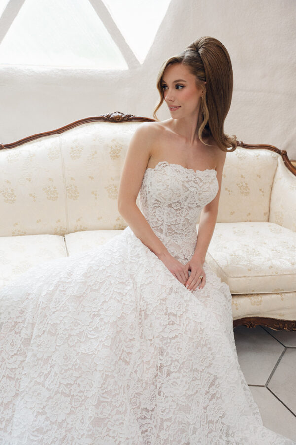 strapless lace wedding dress; vintage inspired lace, blush undertones, basque waist. Sitting woman